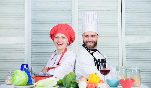 Sfida culinaria finale cucina in famiglia in cucina uomo e donna chef che cucinano uniforme da cuoco vegetariano dieta e cucina culinaria vitaminica cucina coppia felice innamorata di cibo sano