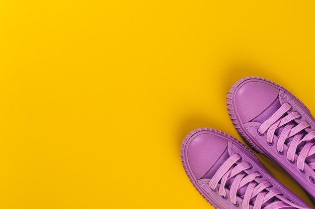 Sneakers ultra violet su sfondo giallo. concetto di stile di vita sano e cibo, allenamento quotidiano e forza di volontà.