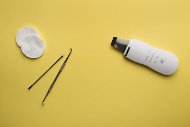 Ultrasonic scrubber, uno spoon lies on a yellow background 