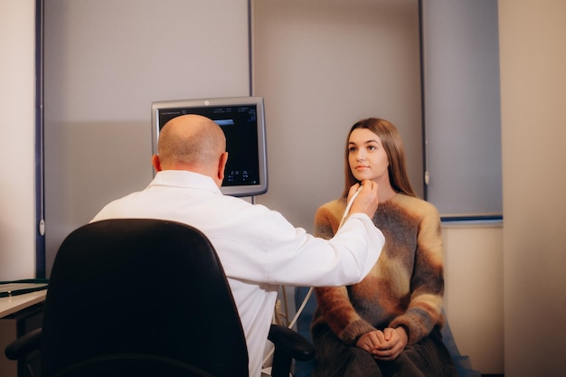 診療所で若い女性の甲状腺の超音波診断