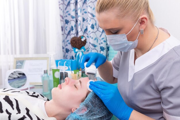 Ultrasound facial peeling Young woman getting ultrasonic peel skin with skin scrubber at cosmetology clinic