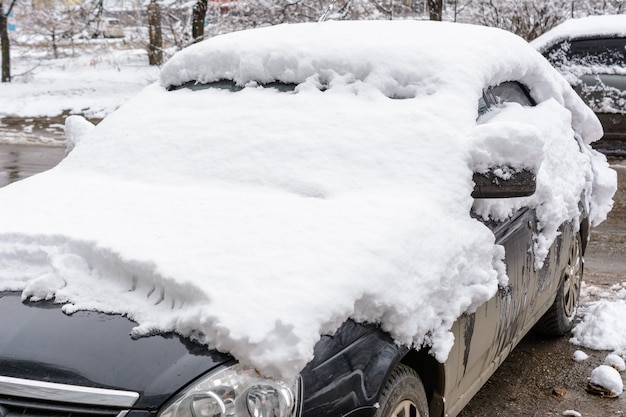 Photo ulyanovsk, russia - december 04, 2019: car covered in fresh white snow, cars covered in snow after a blizzard