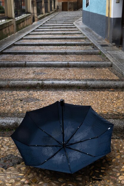 雨の日に石畳の通りに捨てられた傘