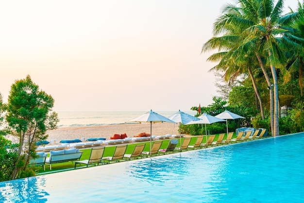 Umbrella and chair around swimming pool with sea ocean view for\
holiday vacation travel concept