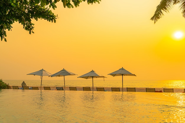 Umbrella and chair around swimming pool with sea ocean view