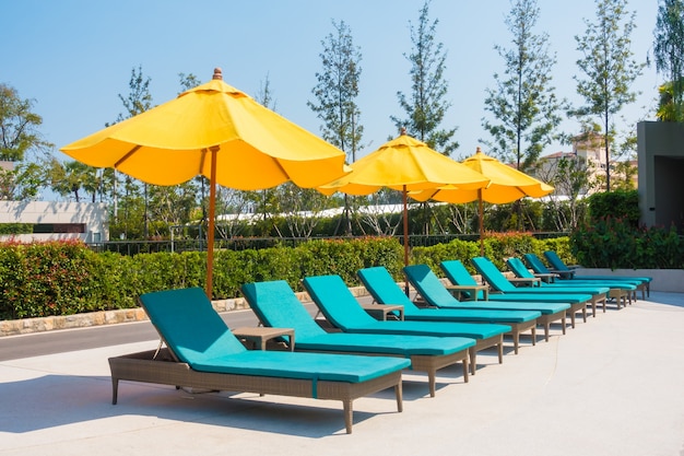 Umbrella and chair around swimming pool