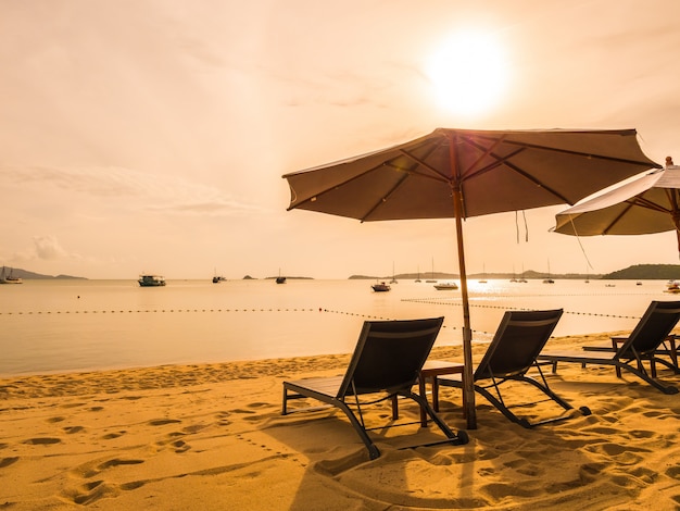 Umbrella and chair on the tropical beach sea and ocean at sunrise time