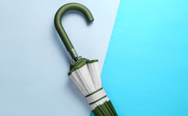 Umbrella handle hook on two-ton blue background. Top view, minimalism