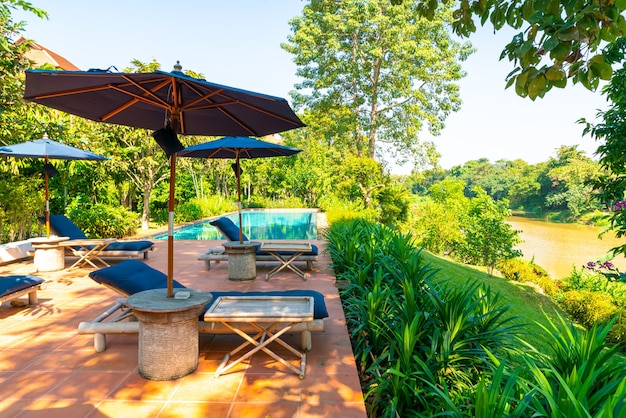 umbrella and pool bed around swimming pool with river view