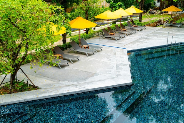 Photo umbrella and pool bed decoration around swimming pool in hotel resort