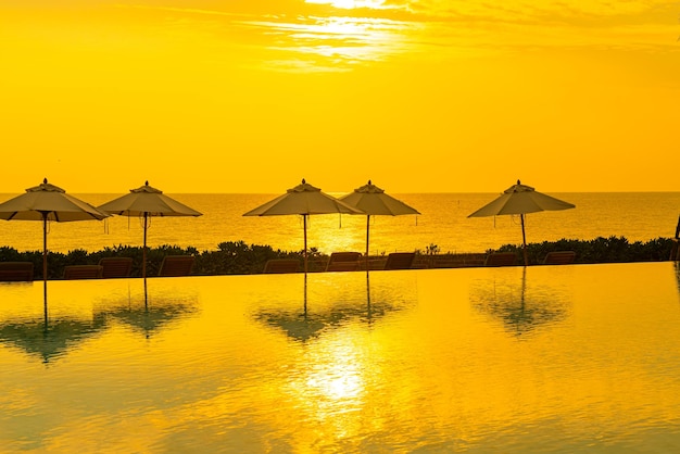 Umbrella with bed pool around swimming pool with ocean sea background