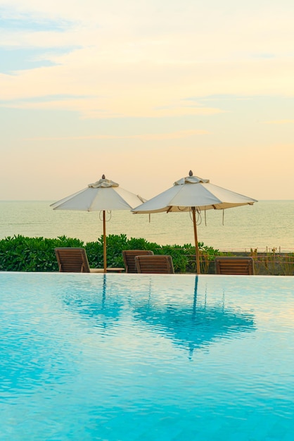 Umbrella with bed pool around swimming pool with ocean sea background