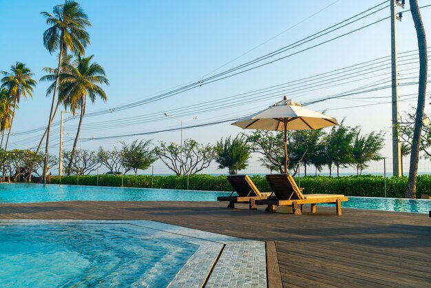 Umbrella with bed pool around swimming pool with ocean sea background