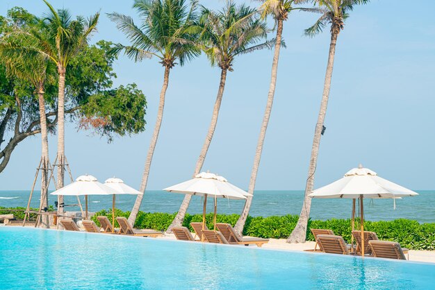 Photo umbrella with bed pool around swimming pool with ocean sea background