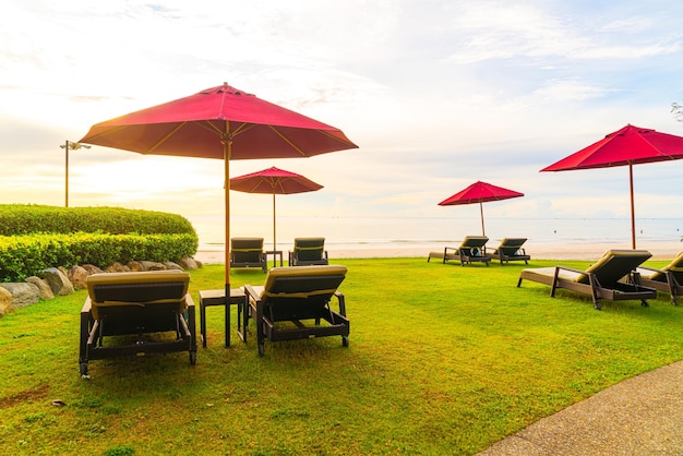 Зонт со стулом на фоне морского пляжа и восхода солнца утром
