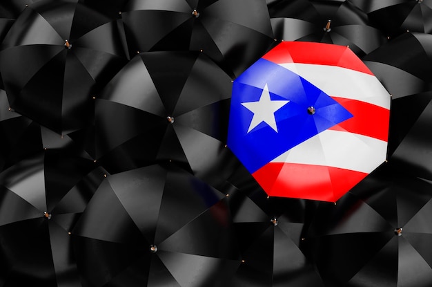 Umbrella with Puerto Rican flag among black umbrellas 3D rendering