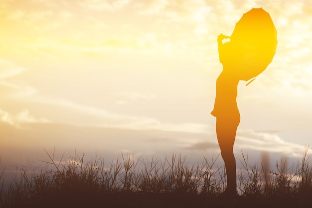 写真 傘の女性と夕日のシルエット