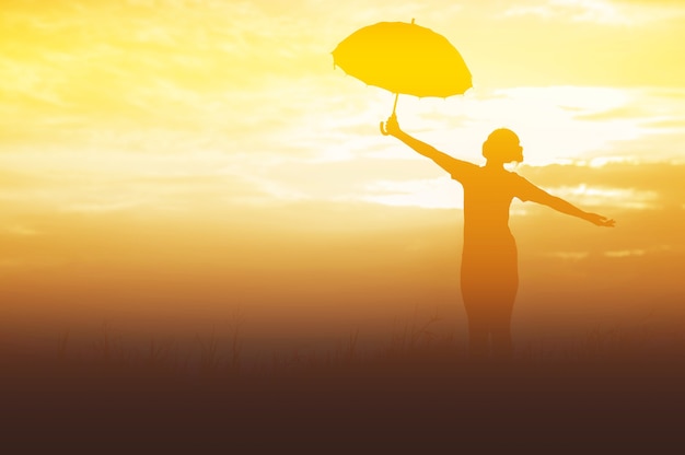 Photo umbrella woman and sunset silhouette