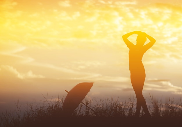 傘の女性と夕日のシルエット