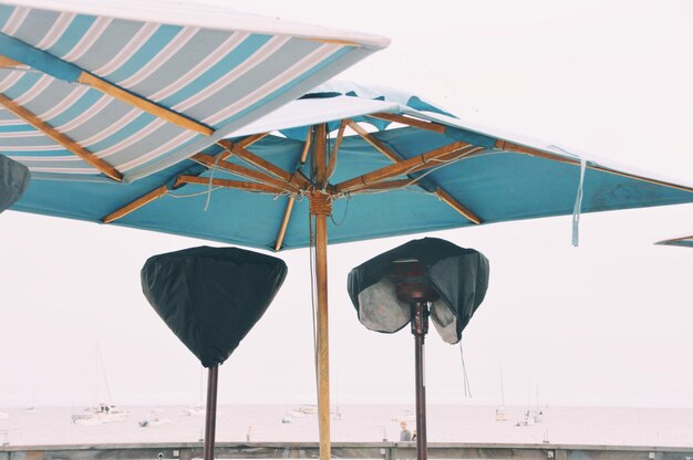 Photo umbrellas by sea against clear sky