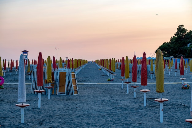 Umbrellas on an empty beach at sunset time