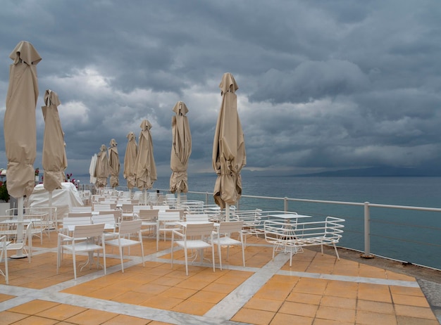 Umbrellas in a Greek tavern without visitors before a thunderstorm in Greece