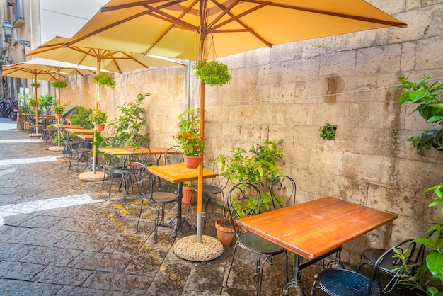 이탈리아 소렌토의 좁은 골목에 있는 우산 테이블과 의자