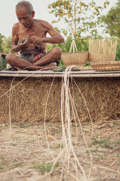 Uncle Asian old man with wicker tools.