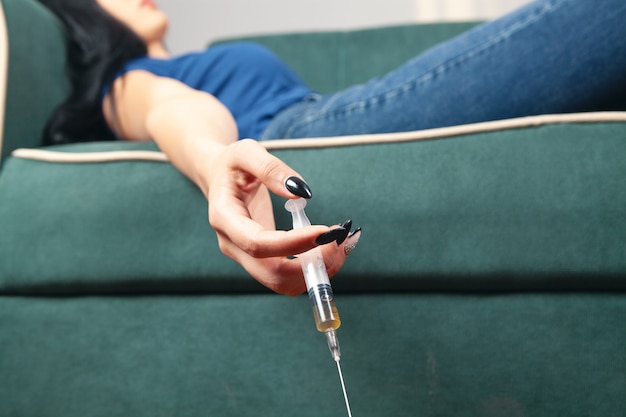 Unconscious woman holding a syringe