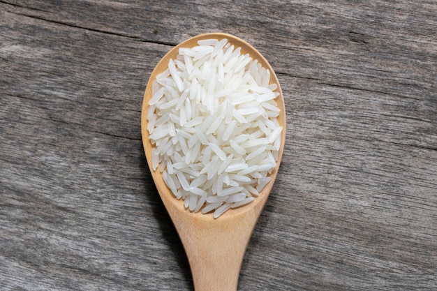 Photo uncook rice in wood spoon