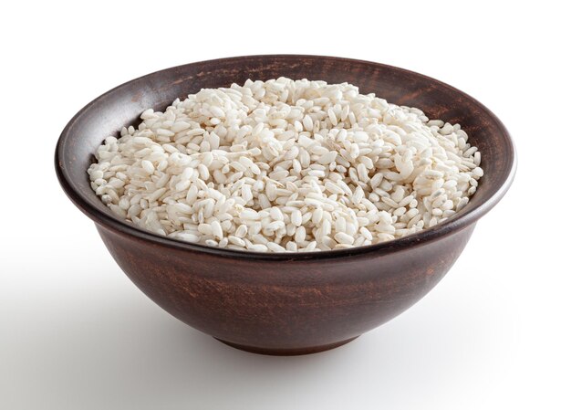 Uncooked arborio rice in ceramic bowl isolated on white background with clipping path