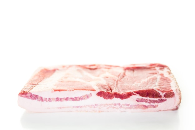 Uncooked bacon strips on a white background.