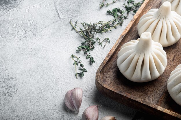 Uncooked Baozi chinese dumplings. Azian dumplings set, on gray stone
