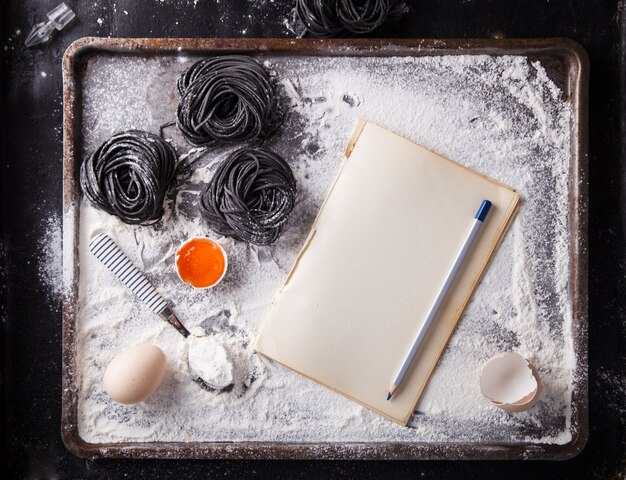 Фото Сырая черная паста и ингредиенты для домашнего спагетти