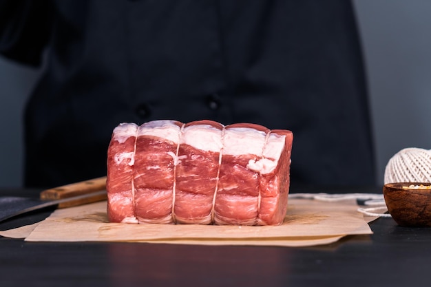 Uncooked boneless pork roast on the brown butcher paper.