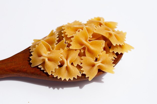 Uncooked bow tie pasta on white background