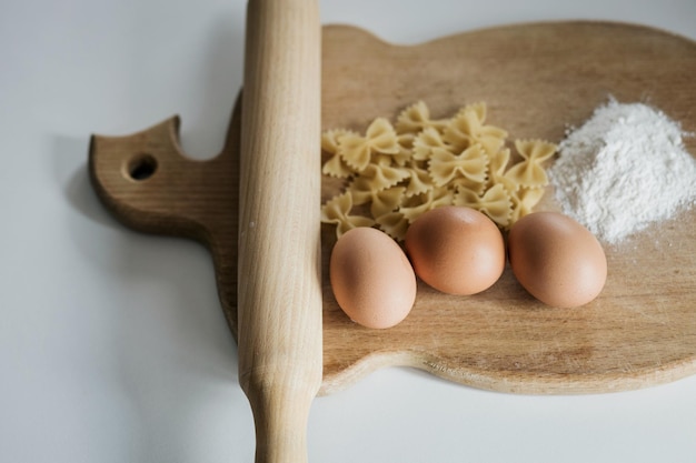 Uncooked bow tie pasta on wooden board