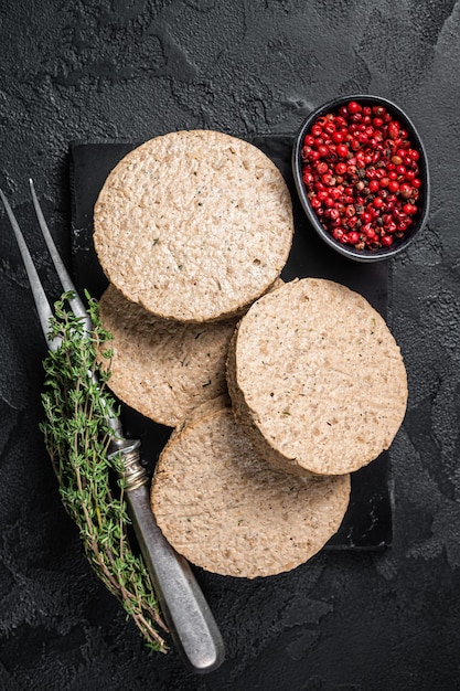 Uncooked Burgers cutlets made from plant based meat raw vegan patties Black background Top view