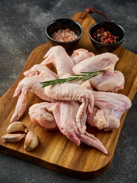 Uncooked chicken wings with pepper and salt on wooden board Raw meat Raw Chicken wings