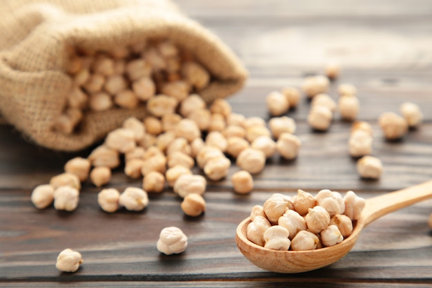 Uncooked chickpeas in wooden spoon and bag