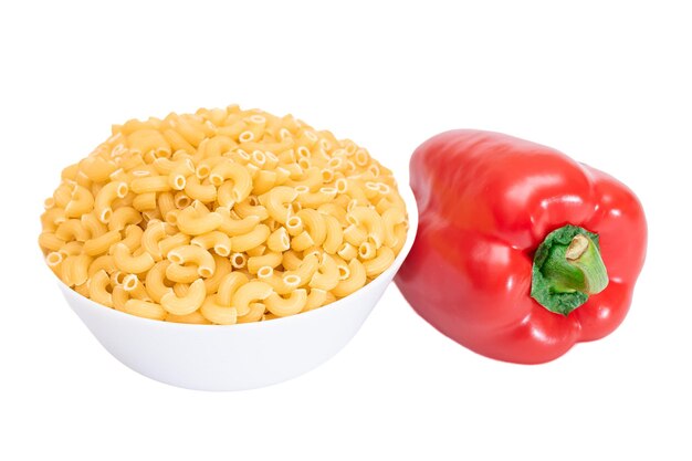 Uncooked chifferi rigati pasta in white cup with red bell pepper isolated