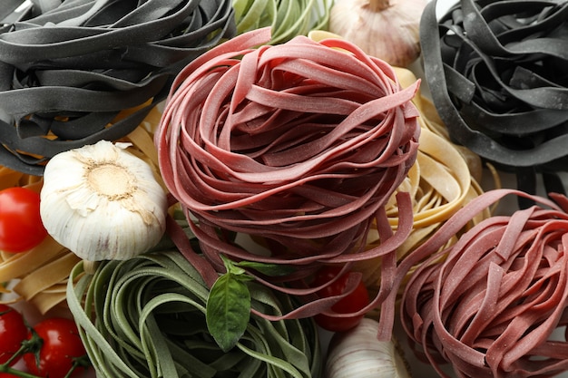 Uncooked color pasta and ingredients, close up