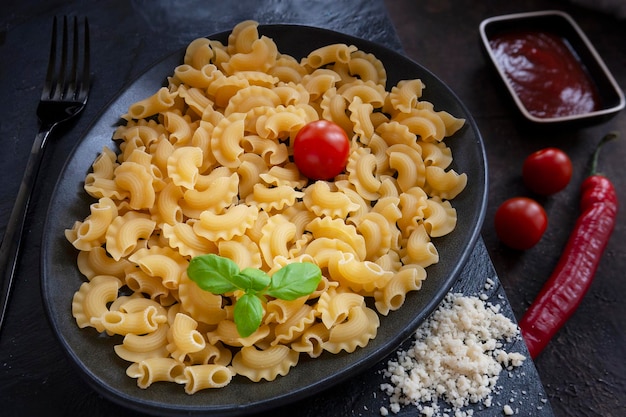 写真 クレステ・ディ・ガロ (creste di gallo) のパスタとその調理用の材料