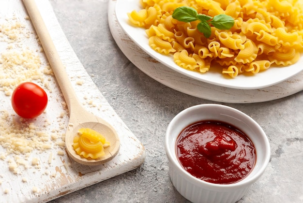 Uncooked Creste di Gallo pasta and ingredients for it cooking