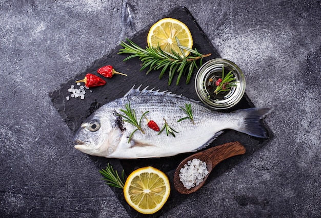 Uncooked dorado fish with rosemary and vegetables