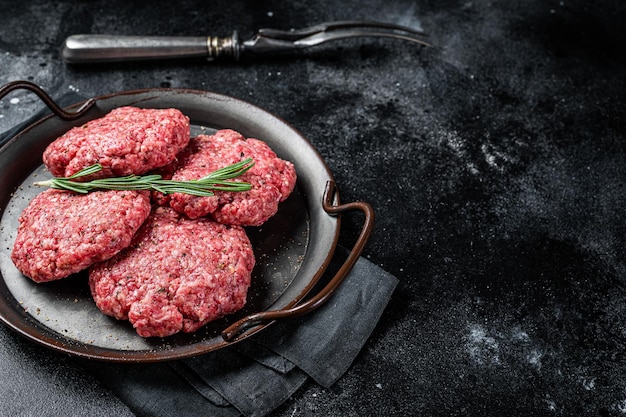 Uncooked Frikadellen from Mince beef Meat raw meat cutlets Black background Top view Space for text