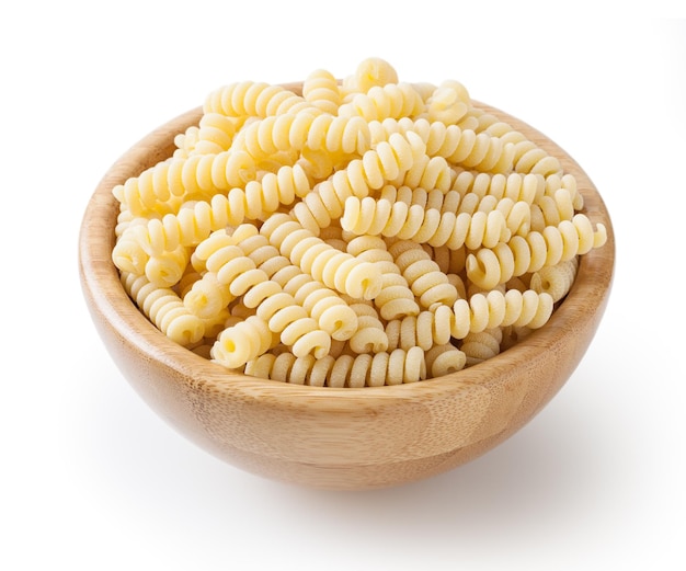 Uncooked fusilli corti bucati pasta in wooden bowl isolated on white background with clipping path