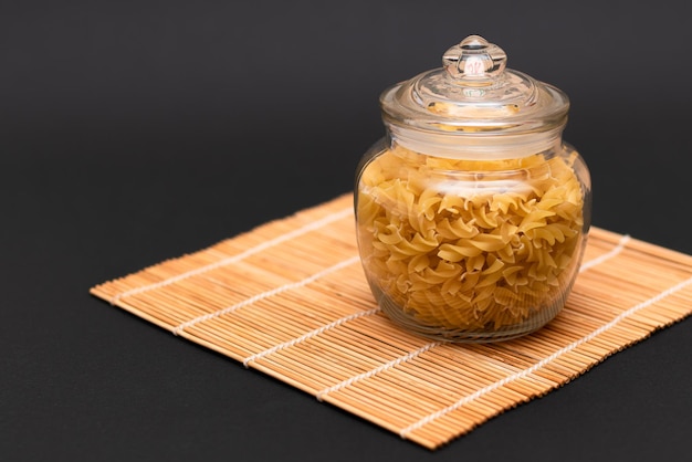 Uncooked fusilli pasta in glass jar