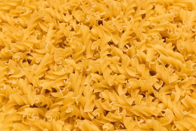 Uncooked fusilli pasta texture background