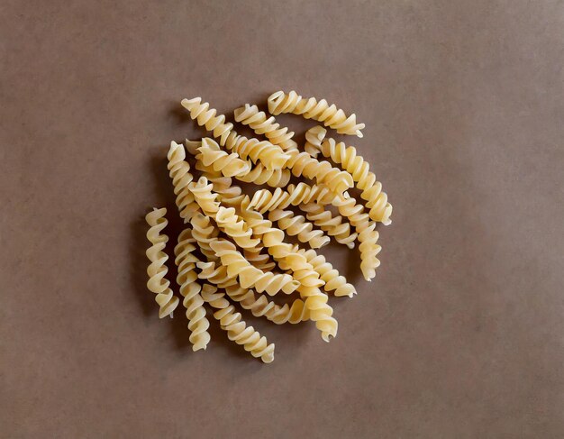 Foto pasta fusilli cruda pasta italiana cruda su sfondo marrone vista dall'alto